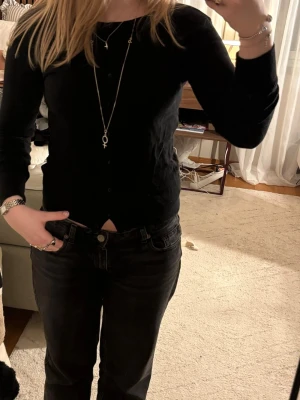 Svart kofta från Primark - En klassisk svart kofta från Primark i tunnare material. Koftan har rund halsringning, långa ärmar och knäppning framtill med små svarta knappar. Perfekt att slänga över en topp eller klänning.