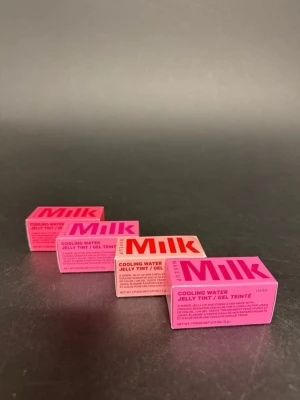 Milk Makeup Cooling Water Jelly Tint - Fyra olika Milk Makeup Cooling Water Jelly Tint i nyanserna Chill, Fresh, Fizz och Burst. Förpackningarna är i starka rosa och koralltoner med tydlig logga. Produkten är en gelrouge som ger en fräsch och naturlig färg till kinderna.