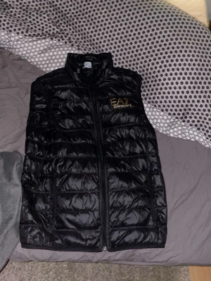Svart dunväst från Emporio Armani - Snygg svart dunväst från Emporio Armani EA7. Har använt den bara 1 gång 