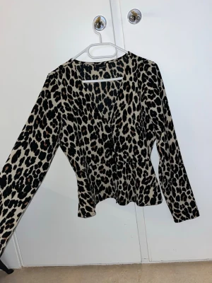 Gina tricot Leopard topp  - En fin leopard mönstrad topp från Gina Tricot. Köpt från stadsmissionen, men aldrig använd efter de då den är lös i midjan. För en mer figurformad passform rekommenderar jag att någon som normalt har S-M köper den. Då den sitter löst på mig som har XS🥰
