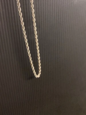 Silverfärgat tvinnat halsband - Säljer ett stilrent halsband i silverfärg med tvinnad kedja. Halsbandet har en enkel men snygg design som passar till många olika stilar. Perfekt accessoar för dig som gillar minimalistiska smycken.