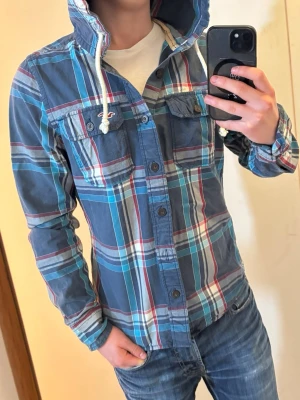 Hollister skjorta  - Tja! Säljer en Hollister skjorta med luva i storleken (S)-skick 9/10. Vid minsta lilla fundering hör av er! Först till kvarn!