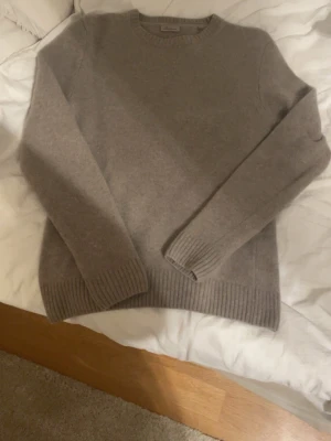 Beige stickad tröja i kashmir - Mysig beige stickad tröja i merino ull tröja med rund halsringning och ribbade muddar vid ärmslut och nederkant. Enkel och stilren design som passar perfekt till lager på lager under kyliga dagar. Passar även S! 2500 ny pris