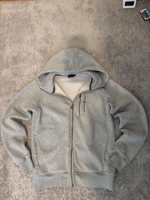 Sail racing hoodie - En ljusgrå Sail Racing zip hoodie i storlek S ☺️ Är som ny och är knappt använd alls ☺️Passar folk som är mellan 170-182 cm långa ☺️hör av er vid frågor ☺️