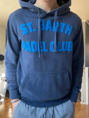 MC2 Saint Barth Hoodie Blå – Strl S – Mycket Fint Skick - Säljer en snygg hoodie från MC2 Saint Barth / St. Barth med stor logga framtill. Premiumkvalitet och väldigt bekväm passform. Mycket fint skick.  • Storlek: S • Färg: Blå • Skick: Mycket fint skick  Perfekt statement-plagg för vardag.