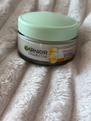 Garnier SkinActive Vitamin C Dagkräm - Glow Boost dagkräm från Garnier SkinActive med vitamin C och citrus. Kommer i en rund glasburk med mintgrönt lock och rymmer 50 ml. Perfekt för dig som vill ha extra lyster och fräschör till huden💛. liten extra gåva vid varje köp! Skickar allt omsorgsfullt i bubbelplast & kartong
