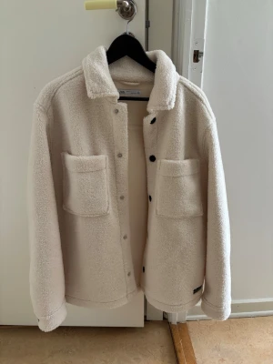 Beige teddy overshirt från Zara - Mysig beige overshirt i teddy-material från  Zara. Säljer då jag knappt användt den. Går ner i pris vid snabbt köp.