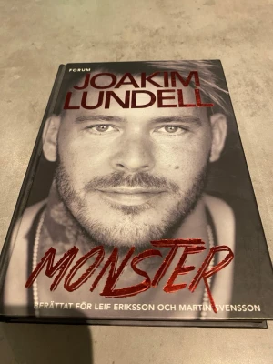 Monster - Leif Eriksson & Martin Svensson - En gripande bok med titeln 'Monster', berättad för Leif Eriksson och Martin Svensson. Omslaget är svartvitt med röd text och ett porträttfoto. Inbunden med hårda pärmar, perfekt för dig som gillar biografiska romaner och verklighetsbaserade berättelser.