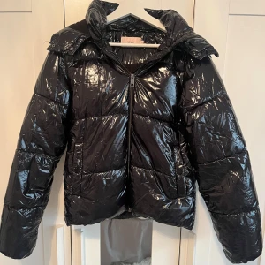 Svart pufferjacka från Nelly - Säljer en snygg svart pufferjacka från Nelly i storlek XS. Lite sliten i innerarmarna längst ner, men inget som syns eller påverkar