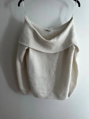 Vit off shoulder stickad tröja Cubus - Säljer en vit stickad tröja från Cubus med bred off shoulder-krage. Tröjan har lång ärm och är gjord i mjukt, fluffigt material som känns riktigt cozy. Perfekt för dig som gillar en avslappnad men ändå trendig look.