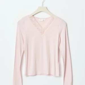 Ljusrosa långärmad topp med spets - Söt ljusrosa långärmad topp från Gina Tricot med v-ringning och spetsdetaljer vid halsen. Toppen har en slim passform och är perfekt att styla med jeans eller kjol för en trendig look.