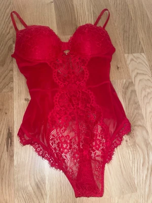 Röd spetsbody med vadderade kupor - Nyskick, bara provad. Snygga populära röda bodyn från H&M, i spets med vadderade kupor och justerbara axelband. Strl S. 