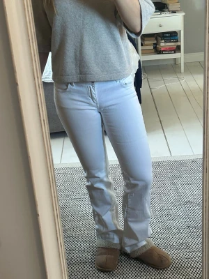 Vita bootcut jeans - Säljer ett par vita bootcut jeans med klassisk femficksdesign och normal midja. Jeansen har en snygg, lätt utsvängd passform och är perfekta för en clean och fräsch look. Materialet är mjukt och stretchigt. Liten i storlek. Strlk 38 men passar mer som en 36