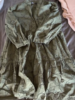 Grön mönstrad klänning med knappar - Ljusgrön klänning med svarta prickiga mönster och knappar framtill. 