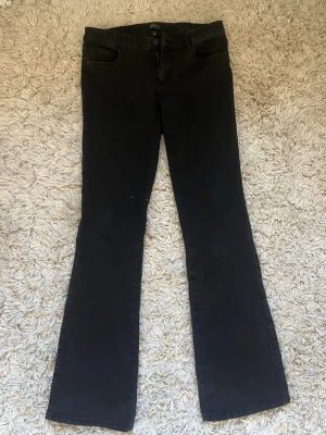 Svarta bootcut jeans från Only - Snygga svarta bootcut jeans från Only med klassisk femficksdesign och knappgylf. Jeansen har en något utsvängd passform nedtill och är tillverkade i stretchigt denimtyg för extra komfort. Perfekta för en trendig och avslappnad look.