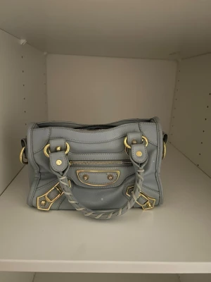 Ljusblå  handväska  - Ljusblå och guld handväska. Trendig modell och rymmer mycket. Kommer med axelband! ❣️❣️❣️ Jätte bra skick!!!
