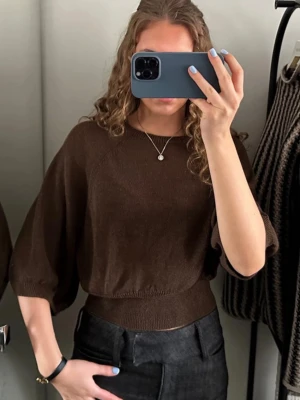 Brun stickad topp  - Säljer en brun stickad topp med bred resår i midjan och trekvarts armar . Tröjan har en rund halsringning och är gjord i ett tunt, mjukt material som sitter snyggt på kroppen. Perfekt för dig som gillar en enkel men trendig look.