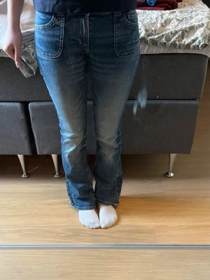 Blå bootcut jeans med stora fickor - Säljer ett par blå bootcut jeans med stora framfickor och snygga detaljer på bakfickorna. Det är storlek 158 på barnavdelningen men de passar mig som brukar ha 34/36. De är inte använda mycket alls. Tryck gärna på köp nu!🫶🏼