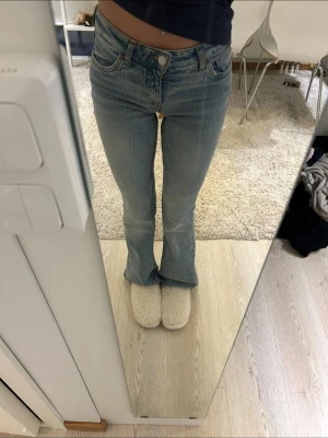 Ljusblå bootcut jeans - Säljer ett par ljusblå bootcut jeans med klassisk femficksmodell och normal midja. Jeansen har en snygg tvätt och lätt utsvängda ben. Perfekta till sneakers eller boots och ger en avslappnad men trendig look. Mango