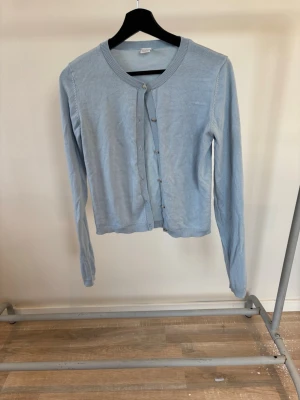 Blå tun kofta med lite glansiga knappar  - Gullig blå kofta är större i storleken så runt xs hade jag sakt.