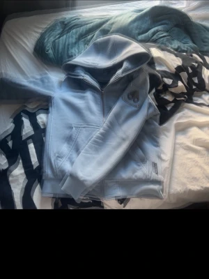 Ljusblå moose knuckles Bunny - Säljer en ljusblå jacka från moose knuckles med quiltad svart insida och stor huva. Jackan har dragkedja framtill, två fickor och en patch med logga på ärmen. Perfekt för kyliga dagar och riktigt snygg streetstil.