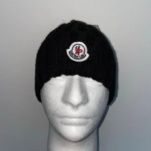 Moncler Mössa, Svart, One size - Helt ny, högkvalitativ replika Storlek: One size  Pris: 349kr Leverans: Skickas inom 24 timmar Observera: Begränsat antal i lager – först till kvarn gäller  