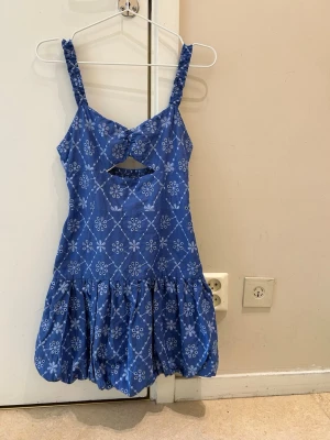  Ny populär Blå kort  klänningen med volang från Zara  - Söt blå kortklänning med vitt blommigt mönster och volang nertill. Klänningen har breda axelband och en snygg cut-out detalj framtill. Perfekt för varma dagar och somriga tillfällen. Egna bilder på annonsen, snabb leverans 