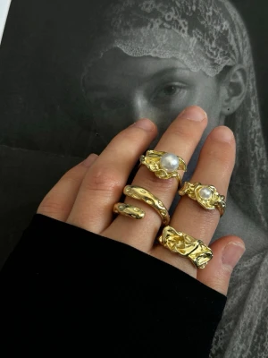 Chunky guldiga statementringar - Fyra chunky ringar i guldigfärg med olika former. Ringarna är i olika storlekar, två har en inner diameter på 1.7cm och två 1.9cm. Oanvända.