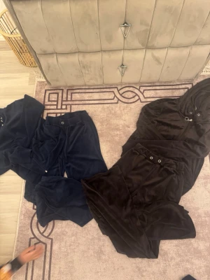 Mysiga velourset i blått och brun - Två loungewear-set i mjuk velour, ett i mörkblått och ett i brunt. Båda seten består av långärmad tröja med huva och matchande byxor med dragsko i midjan. Perfekta för chill hemma eller mysiga dagar.