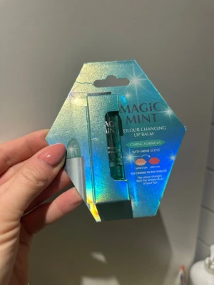 Magic Mint färgskiftande läppbalsam - Magic Mint Colour Changing Lip Balm med mintdoft. Läppbalsamet är grönt i hylsan men ändrar färg till rosa eller röd beroende på läpparnas temperatur. Kommer i en glansig, turkos förpackning och har en vårdande formula med fräsch mintkänsla.
