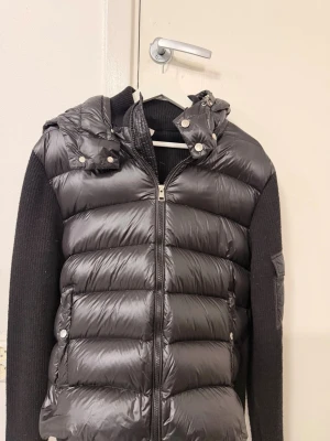 Moncler Cardigan - Cardigan med stickade ärmar.  Har haft jackan i ca 4 år har varit oanvänd i 2 år. Strl XL men passar även L.