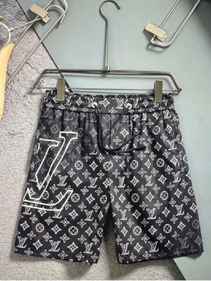 Svarta med monogram - Snygga svarta shorts från klassiskt vitt monogramtryck över hela plagget och stort logga på ena benet. Shortsen har elastisk midja med snörning och är perfekta för en trendig streetstyle-look.