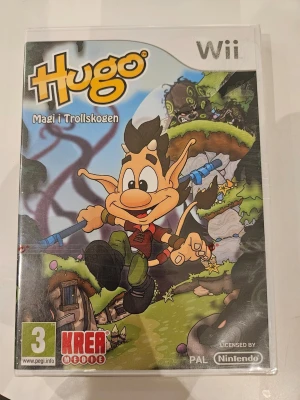 Hugo Magi i Trollskogen Wii spel - Hugo Magi i Trollskogen är ett äventyrsspel till Nintendo Wii där du följer Hugo genom magiska miljöer i trollskogen. Omslaget är färgglatt med Hugo i centrum och spelet är på svenska. Passar för spelare från 3 år och uppåt.