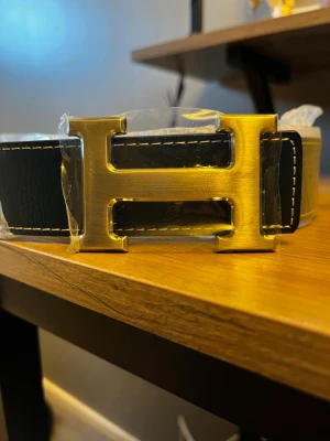 Her-mes bälte - Hej, säljer en riktigt snygg och helt ny bälte, den är oanvänd och storleken står på 110cm. Allt i bilden ingår även armband!