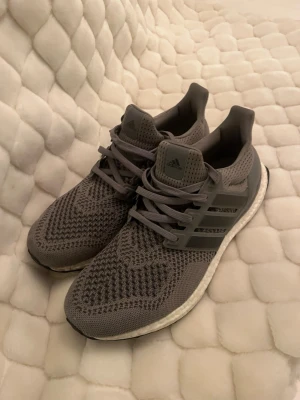 Grå Adidas Ultra Boost  - Säljer ett par gråa adidas Ultraboost i bra skick. Skorna är använda ca 3 gånger. Bara att höra av dig vid frågor och funderingar. Finns att hämta i Vasastan, men kan även fraktas.
