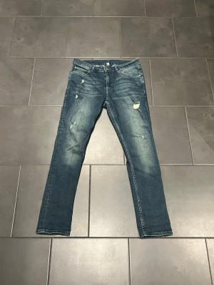 Jeans med slitningar  - Snygga blå jeans med raka ben och slitningar. Bra skick. Storlek W30 L30 