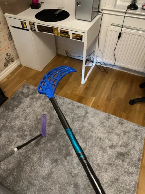 Unihoc evolabe 96 flex 29 - Säljer en innebandyklubba från unihoc med svart skaft och blått blad. Klubban har detaljer i turkos och ett grepp i grått. Perfekt för dig som gillar innebandy och vill ha en snygg och lätt klubba att spela med. Ny pris 2400