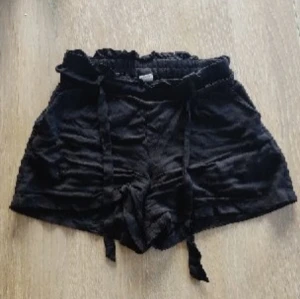 Svarta shorts med knytband - Svarta shorts med avtagbart knytband. Hela och fläckfria men är skrynkliga/veckade (även efter tvätt).