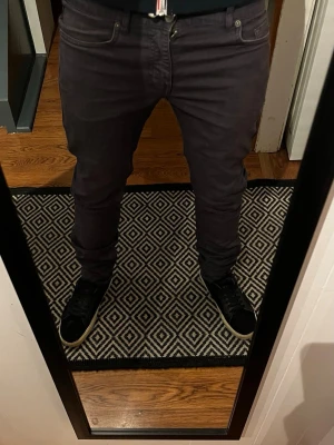 Mörkgrå slim fit jeans - Säljer ett par mörkgrå slim fit jeans med klassisk femficksdesign och dragkedjegylf. Jeansen har en smal passform och är perfekta för dig som gillar en modern och stilren look. Materialet känns mjukt och stretchigt för extra komfort. J. Lindberg jeans.