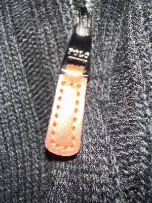 Svart stickad tröja Polo Ralph Lauren - Snygg svart stickad tröja från Polo Ralph Lauren med dragkedja och detaljer i brunt läder på zip-pullern. Tröjan har ribbstickad struktur och hög krage, perfekt för lager på lager och en clean look.