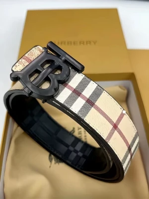 Rutig Burberry skärp med BB-spänne - Snyggt skärp från Burberry med klassiskt rutigt mönster i beige, svart, vitt och rött. Skärpet har ett stort BB-spänne i svart metall och är gjort i skinn. Perfekt accessoar för att lyfta vilken outfit som helst.
