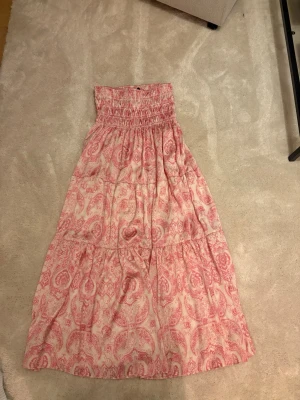 Lång paisleymönstrad kjol rosa/vit - Säljer en lång kjol från Maje. Den är väldigt stretchig i midjan så passar de flesta storlekar. 