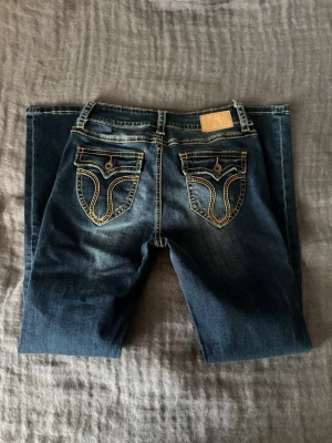 True religion liknande jeans  - Snygga och sköna mörkblå jeans från ATT som har många detaljer som liknar true religion. Modellen har låg midja och skön passform men de är lite smala så man kan sy om till bootcut eller klippa till shorts. 