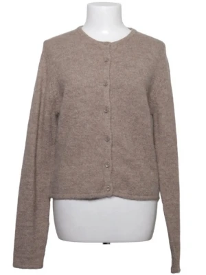 Beige kofta med rund hals - Mysig beige kofta med rund halsringning och knappar framtill. Koftan har lång ärm och är tillverkad i ett mjukt, stickat material som ger en avslappnad look. Perfekt att slänga över en t-shirt eller topp för extra värme.