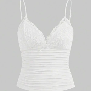 Vit spetslinne med smala axelband - Supersöt vit linnetopp med tunna axelband och spetsdetaljer över bysten. Toppen har v-ringning och en liten rosett framtill. Sitter tight och är perfekt för lager-på-lager eller som den är. Materialet känns mjukt och stretchigt.