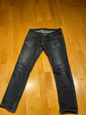 Nudie jeans Raw - Hej! Säljer nu ett par super feta jeans från märket Nudie! De är från början raw denim och har fått dessa coola fades efter jag använt jeansen under en lång tid.   De är lagade och förstärkta i skrevet och även på en av framfickorna. Detta gör så att jeansen har flera år av användning kvar. Samt lagade på ena bakfickan.  De är i storlek 32 32 men sitter som 30 30. De är uppsydda och sitter bra på mig som är 174 och väger 65 kg.   Midja : 42 cm Ytterbensmått : 93 cm Innerbensmått : 70 cm  Mvh H