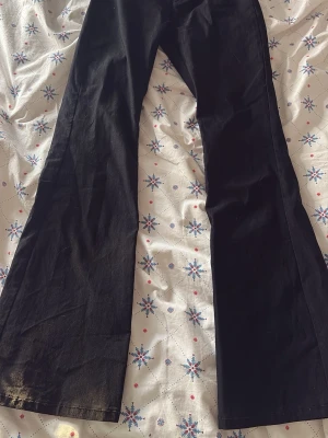 Svarta utsvängda kostym byxor  - Säljer ett par svarta utsvängda kostymbyxor med fickor där bak. Byxorna är i ett mjukt tyg som känns bekvämt, storlek 152❣️