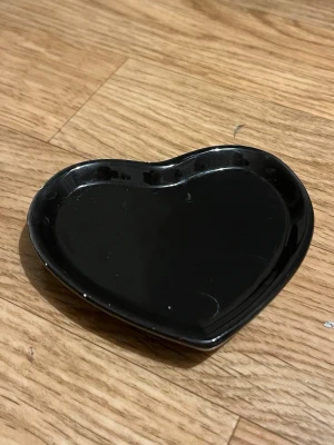 Svart hjärtformad smyckesbricka - En svart hjärtformad bricka i plast, perfekt för att lägga ut smycken.