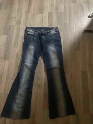 Blå utsvängda jeans Cheap Monday - Säljer ett par blå jeans från Cheap Monday med utsvängda ben och klassisk femficksmodell. Storlek 31/32 mindre i storleken. Klippta snyggt längst ner passar dig som är under 164