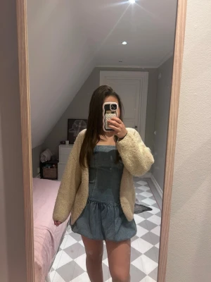 Blå jeansklänning med tubtopp  - Säljer en söt blå jeansklänning med tubtopp och kort kjol. Klänningen har en avslappnad passform och är perfekt för varmare dagar. Enkel och stilren design som passar till många olika looks. (Köpt i Italien) 